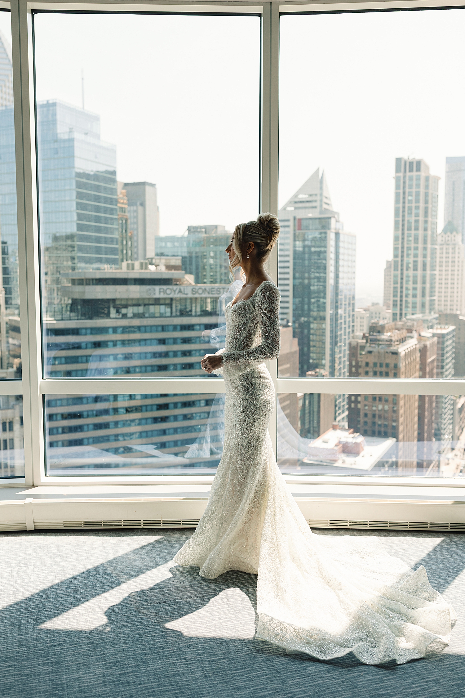 bride stands in front of large windows preparing for day at RPM Events