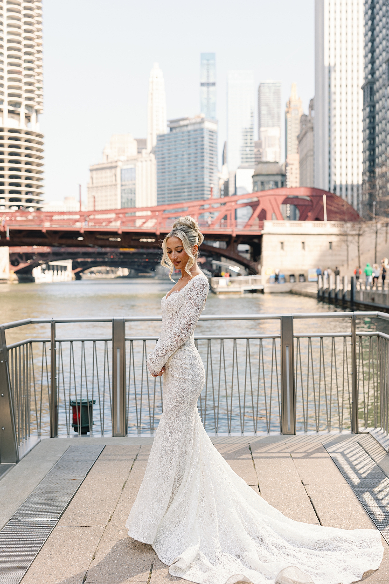 bride stands near water outside by Rachel Andrade Photography
