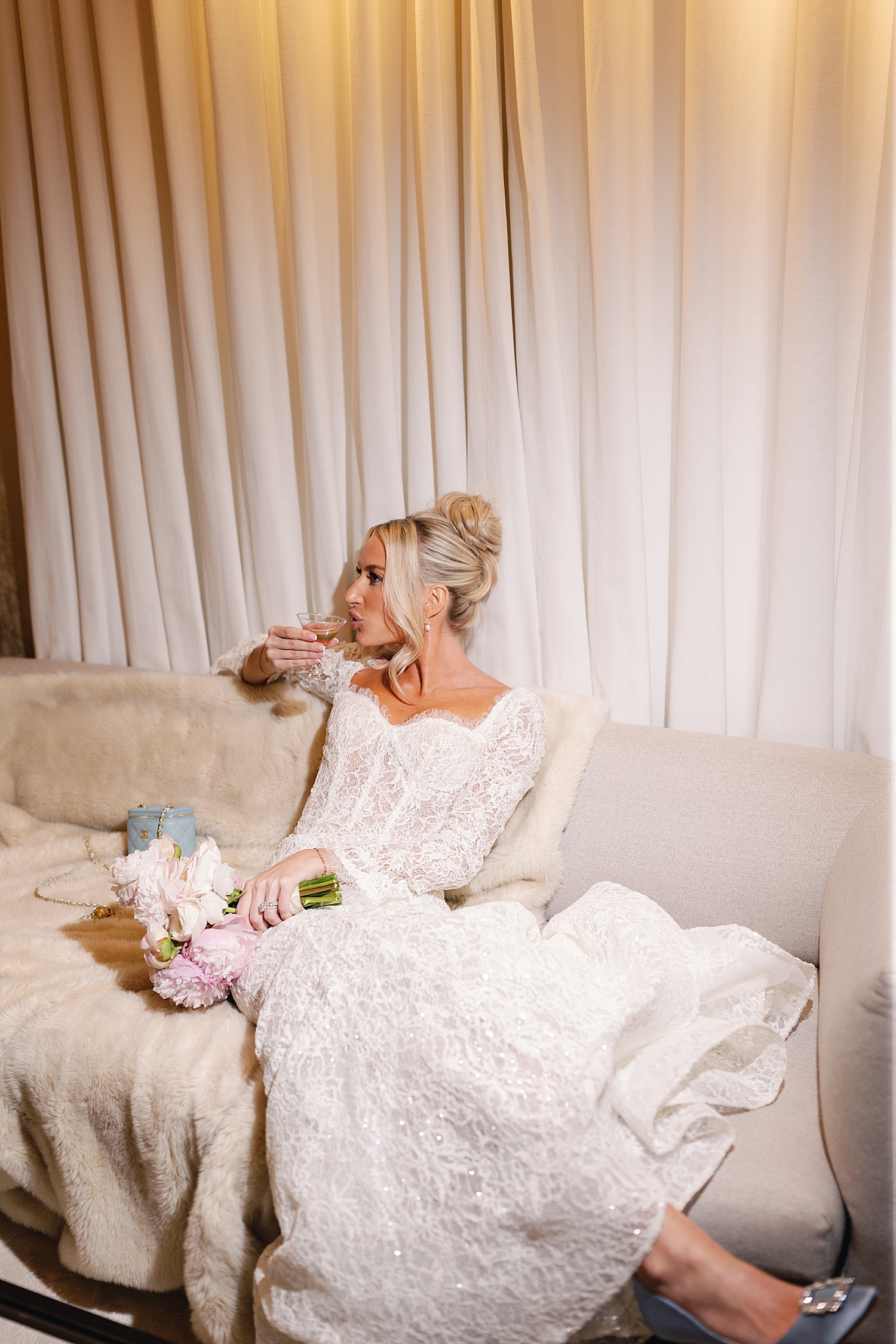 new wife sits on white couch and sips drink at RPM Events