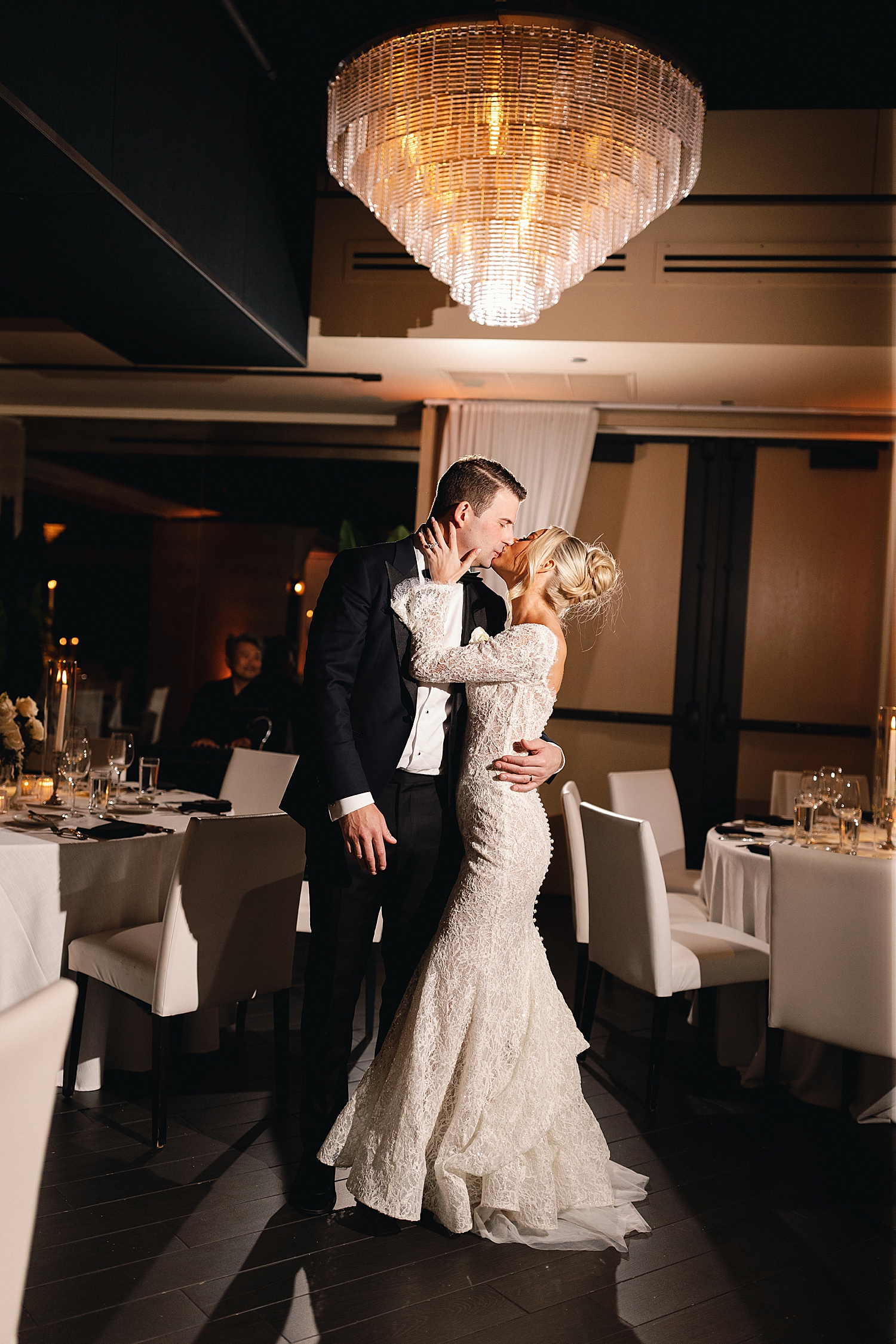 newlyweds kiss in reception hall by Chicago luxury wedding photographer