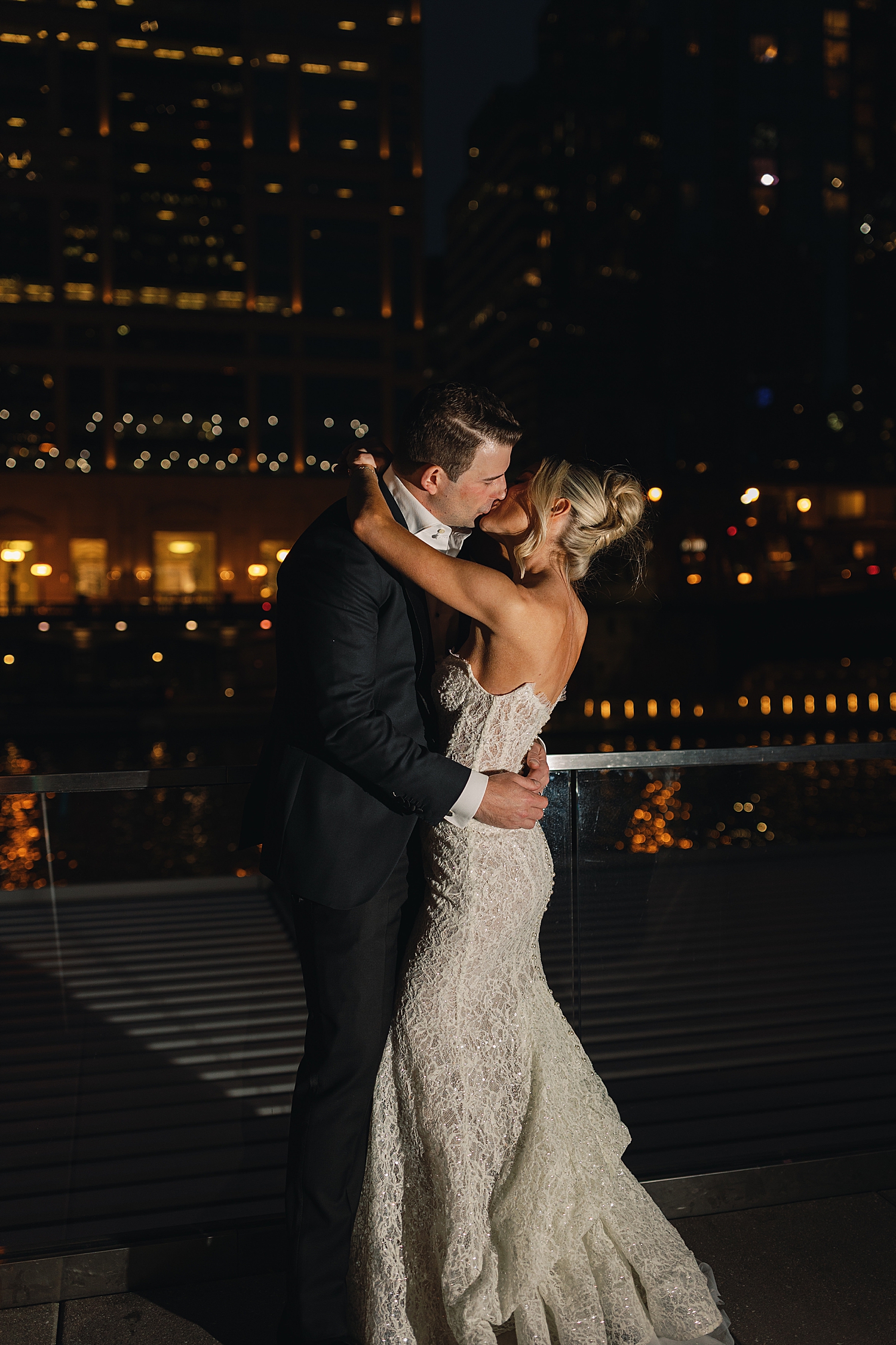 newlyweds share a nighttime kiss on street by Chicago luxury wedding photographer