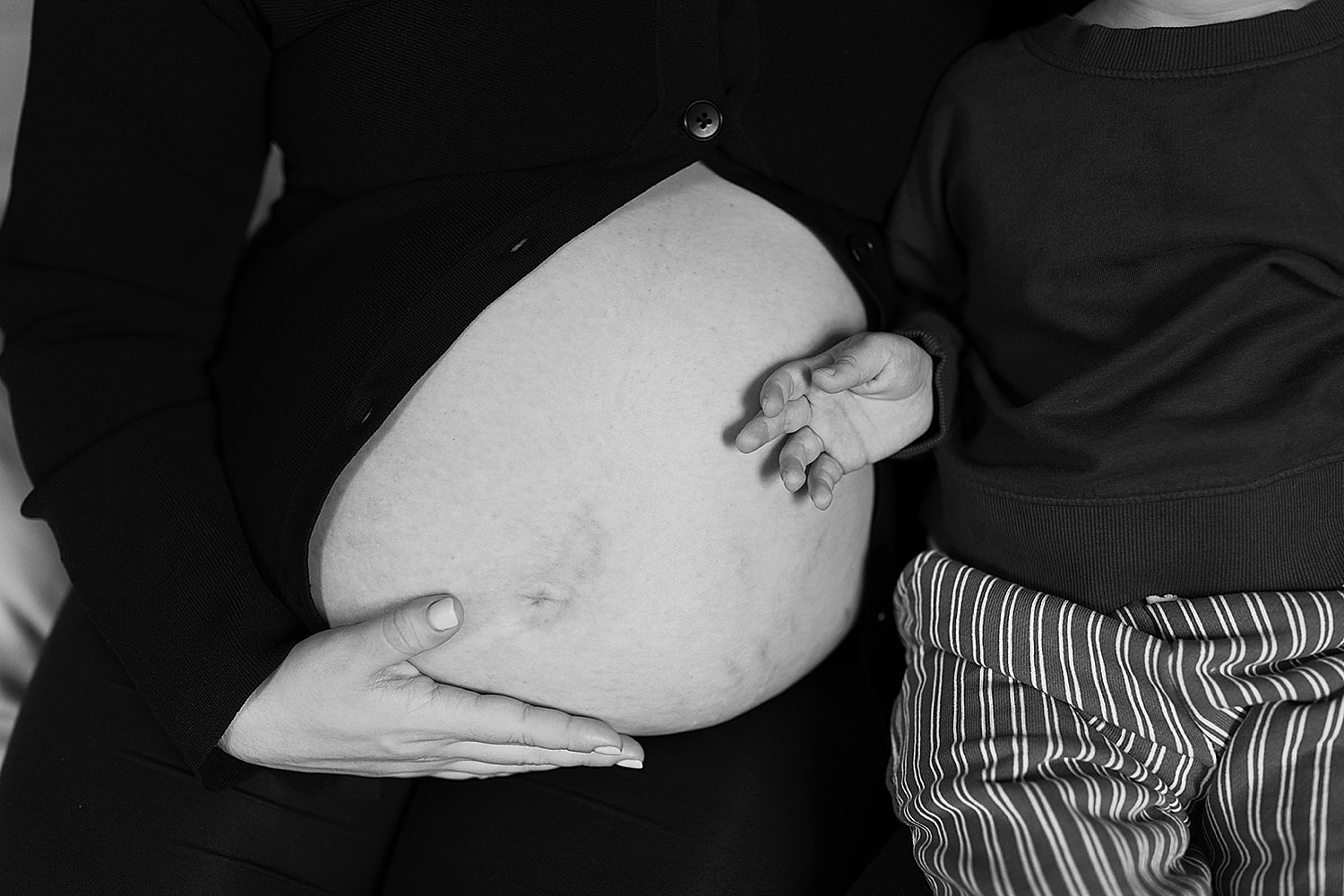 toddler's hands resting on his mother's pregnant belly by Rachel Andrade Photography