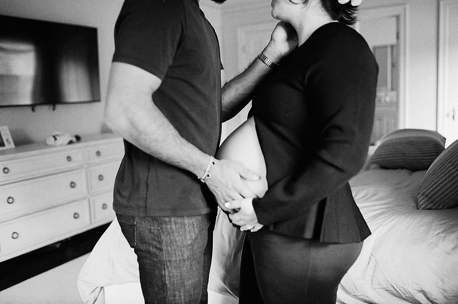 husband and wife cradle baby bump together by Rachel Andrade Photography
