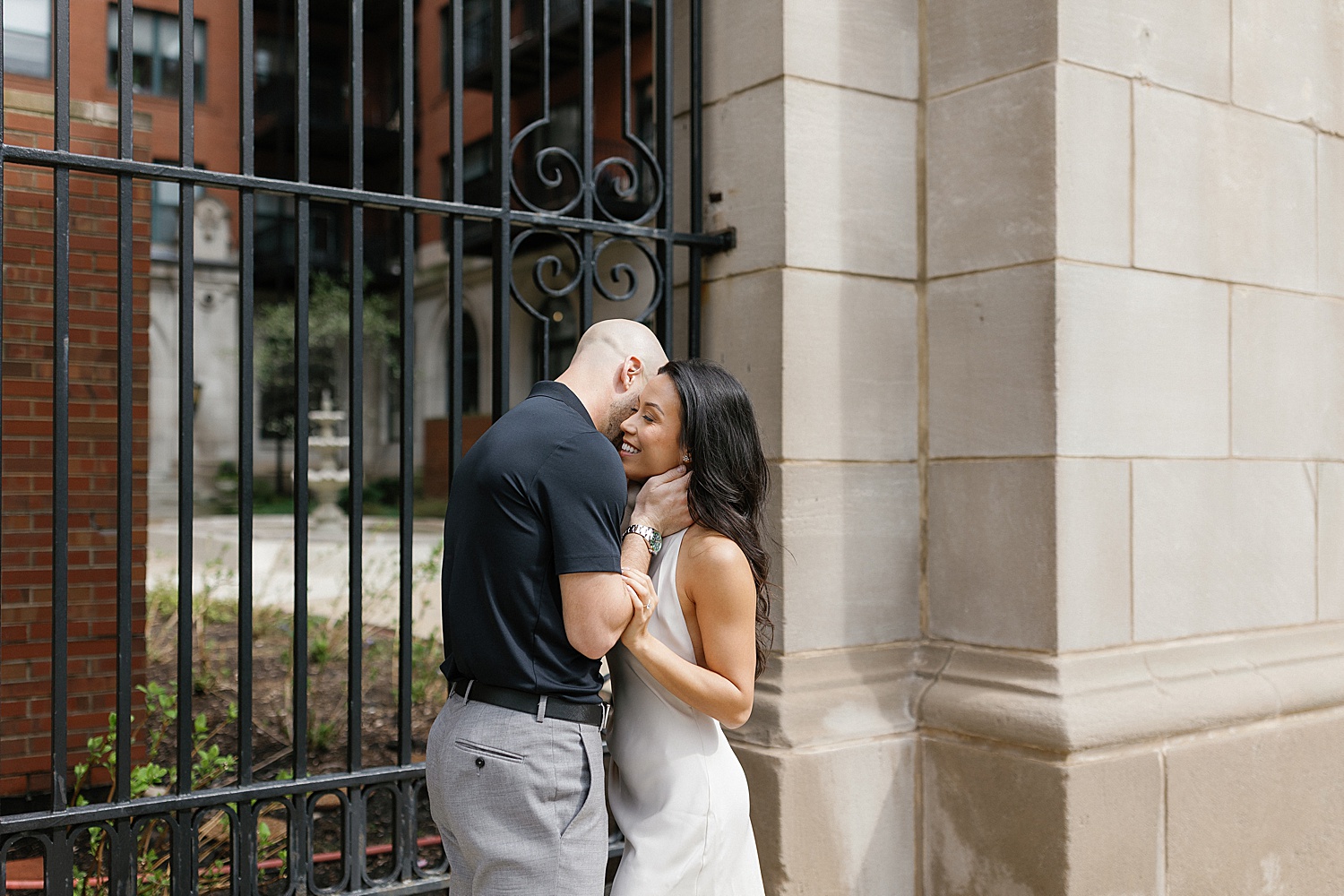 man holds woman closely outside archway by Rachel Andrade Photography