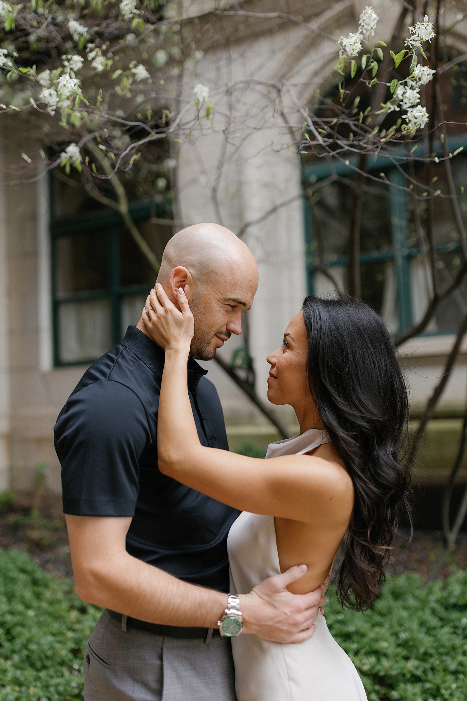 man and woman embrace in front of tree by Chicago wedding photographer