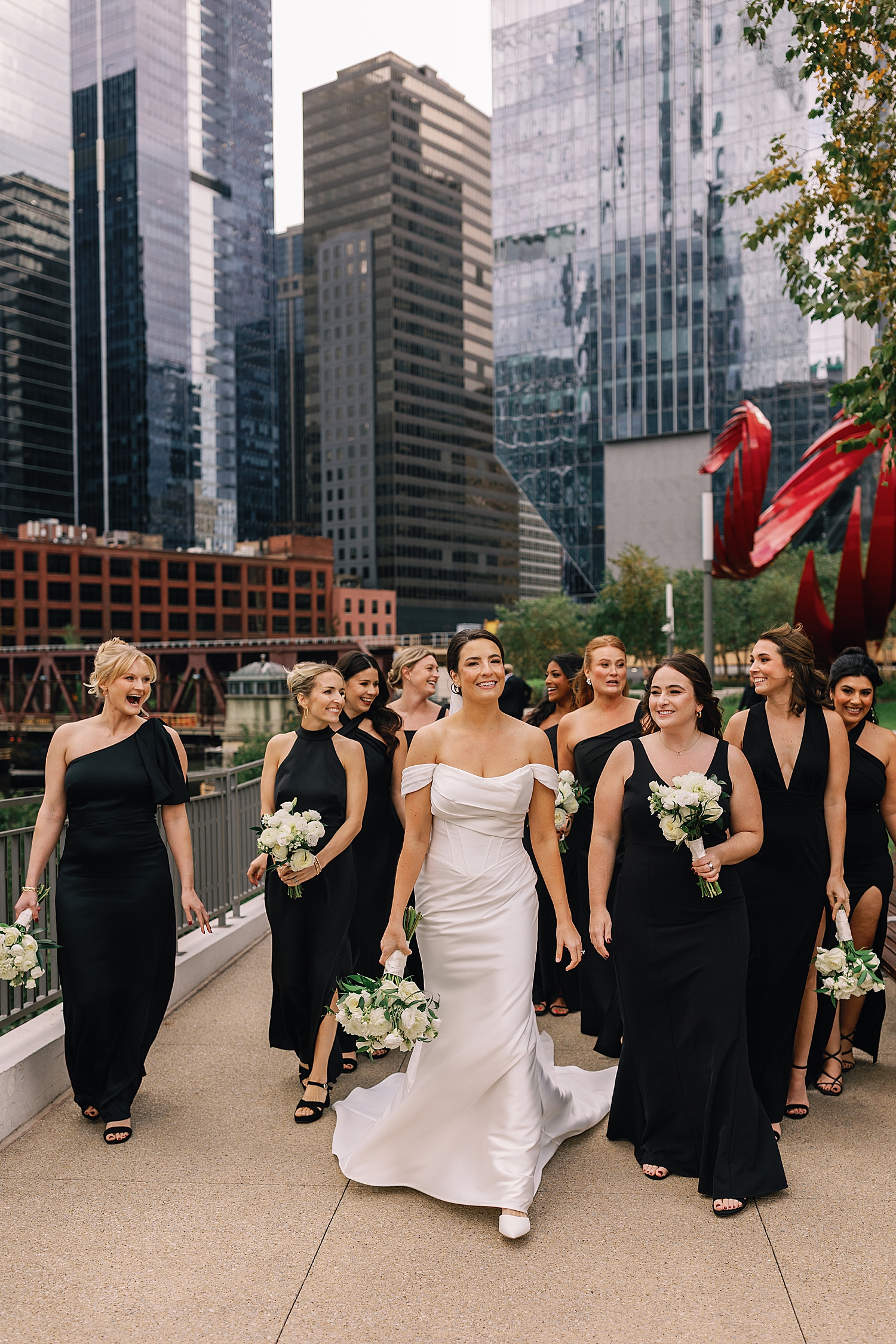 bridesmaids walk with bride next to water near The Drake