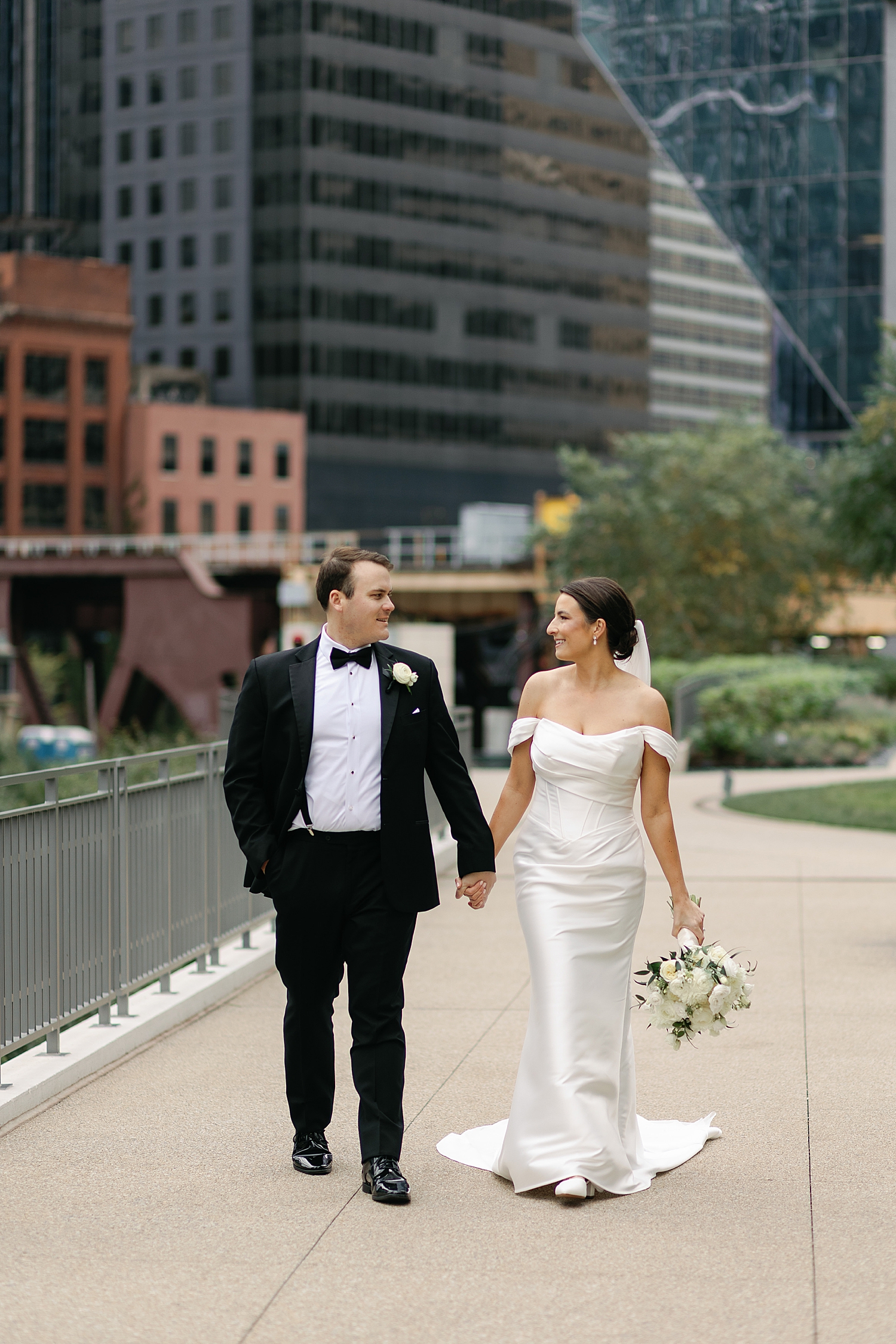 bride and groom walk near water in chicago before day at The Drake